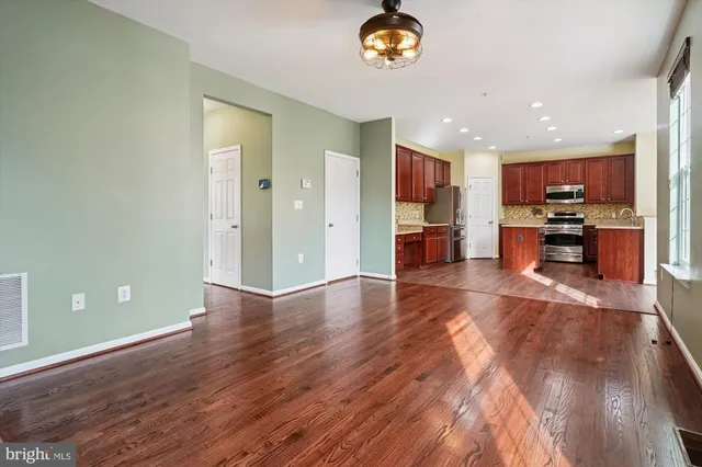 an empty room with wooden floor and mirror