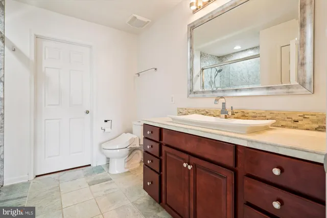an empty room with wooden floor chandelier fan and windows
