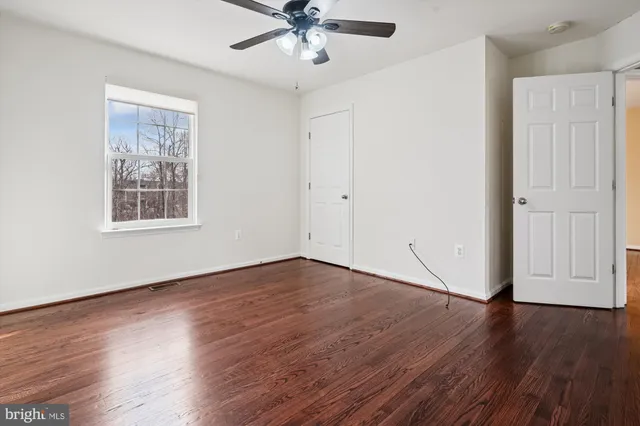 a view of a hallway with wooden floor and entryway