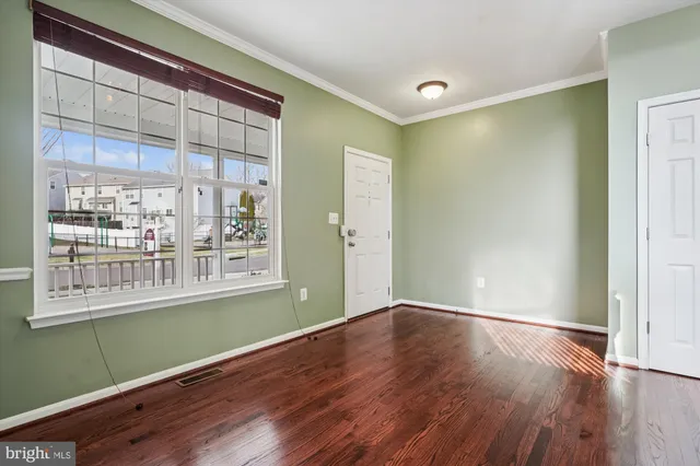a view of a room with wooden floor and a window