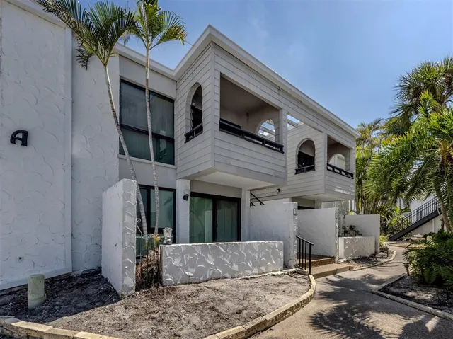 a view of a house with a couches chair and potted plants with sky view