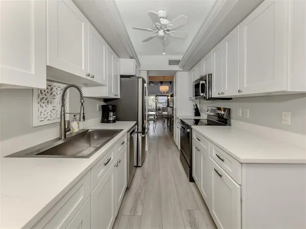 a kitchen with kitchen island granite countertop a sink appliances cabinets and a counter top space