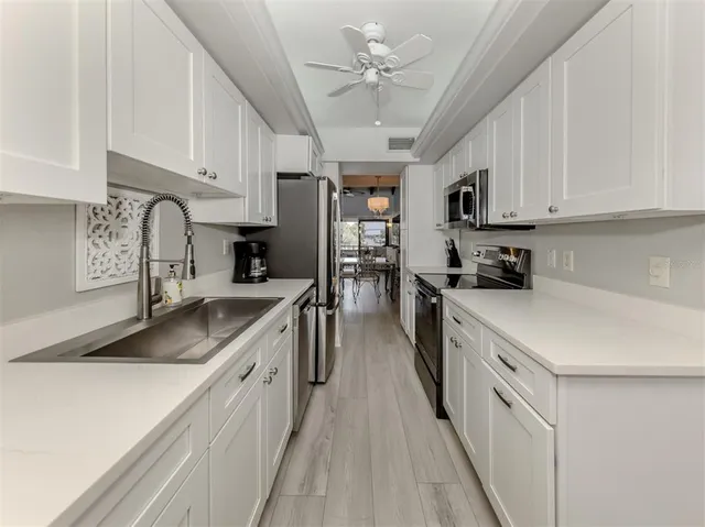 a kitchen with kitchen island granite countertop a sink appliances cabinets and a counter top space