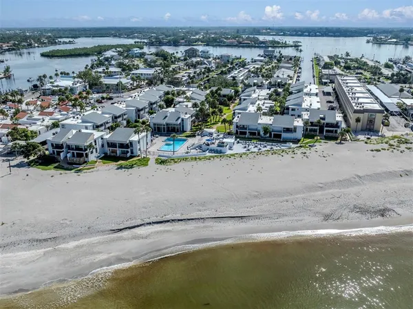 an aerial view of residential houses with outdoor space and ocean view