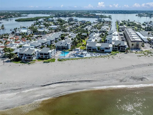 an aerial view of residential houses with outdoor space and ocean view