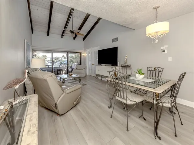 a living room with furniture a chandelier and a flat screen tv
