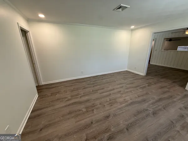 an empty room with wooden floor and entrance