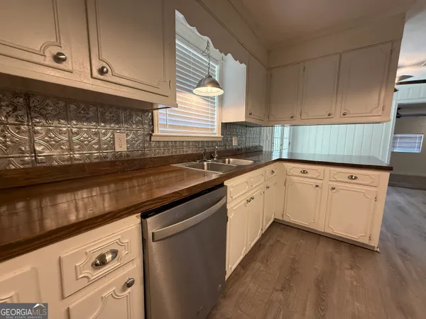 a kitchen with granite countertop white cabinets and white appliances