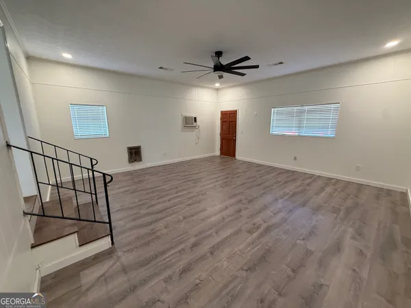 en empty room with wooden floor and windows