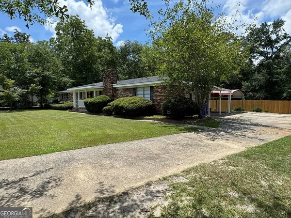 a front view of a house with yard and green space