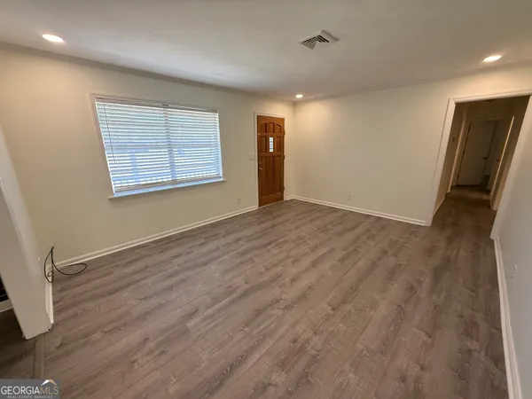 an empty room with wooden floor and a window