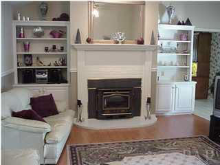 2442 Tate Road Cantonment, FL 32533 - Photo 4 of 15 Great room with fireplace, built-in bookcases, hardwood floors and french doors to sun room.