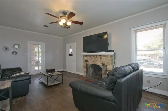 a living room with furniture a flat screen tv and a fireplace