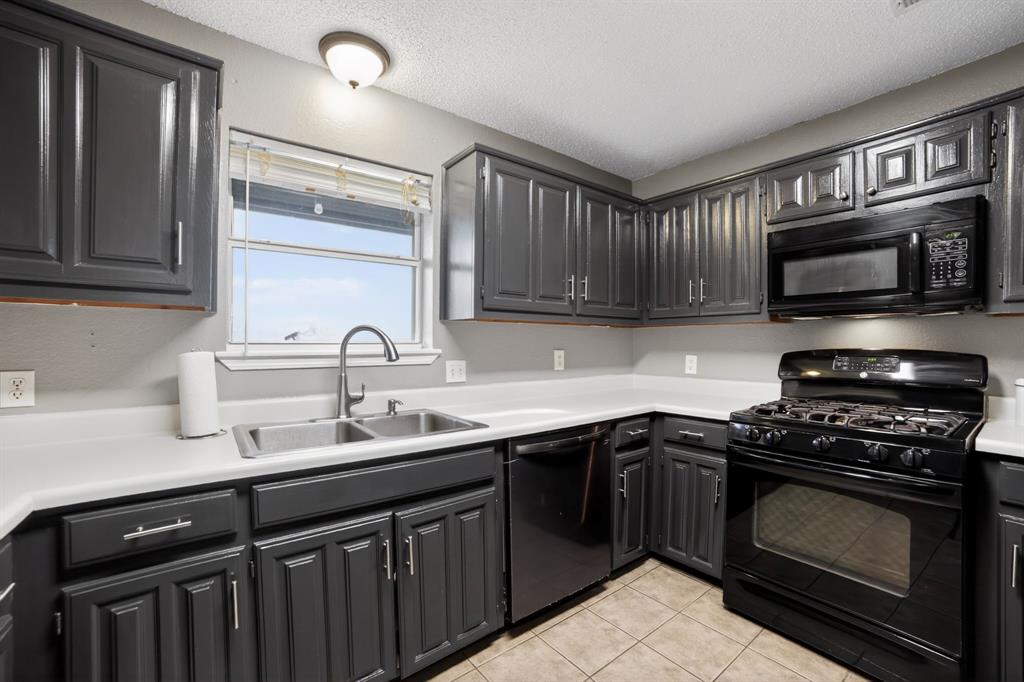 116 Curtis Lane Quinlan, TX 75474 - Photo 18 of 31 a kitchen with sink a microwave and cabinets