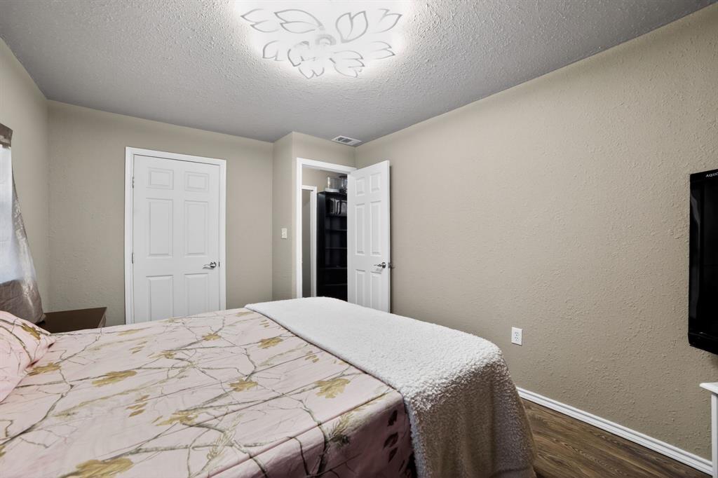 116 Curtis Lane Quinlan, TX 75474 - Photo 22 of 31 a bedroom with a bed and a chandelier