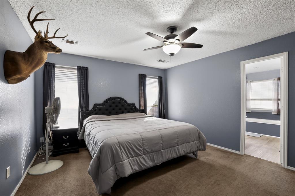 116 Curtis Lane Quinlan, TX 75474 - Photo 8 of 31 a bedroom with a bed and a chandelier