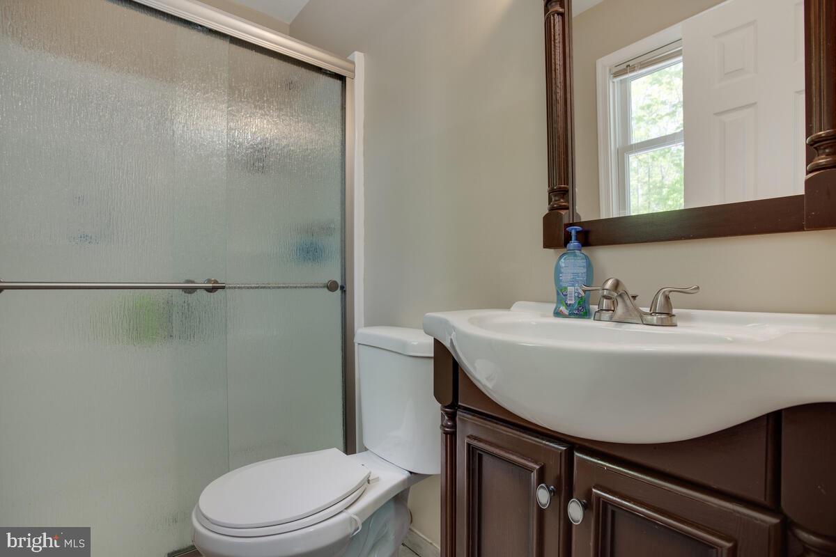 1420 Wilson Road Huntingtown, MD 20639 - Photo 30 of 43 a bathroom with a sink a toilet a mirror and shower