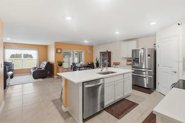 a kitchen with stainless steel appliances a stove a sink a microwave a refrigerator and cabinets