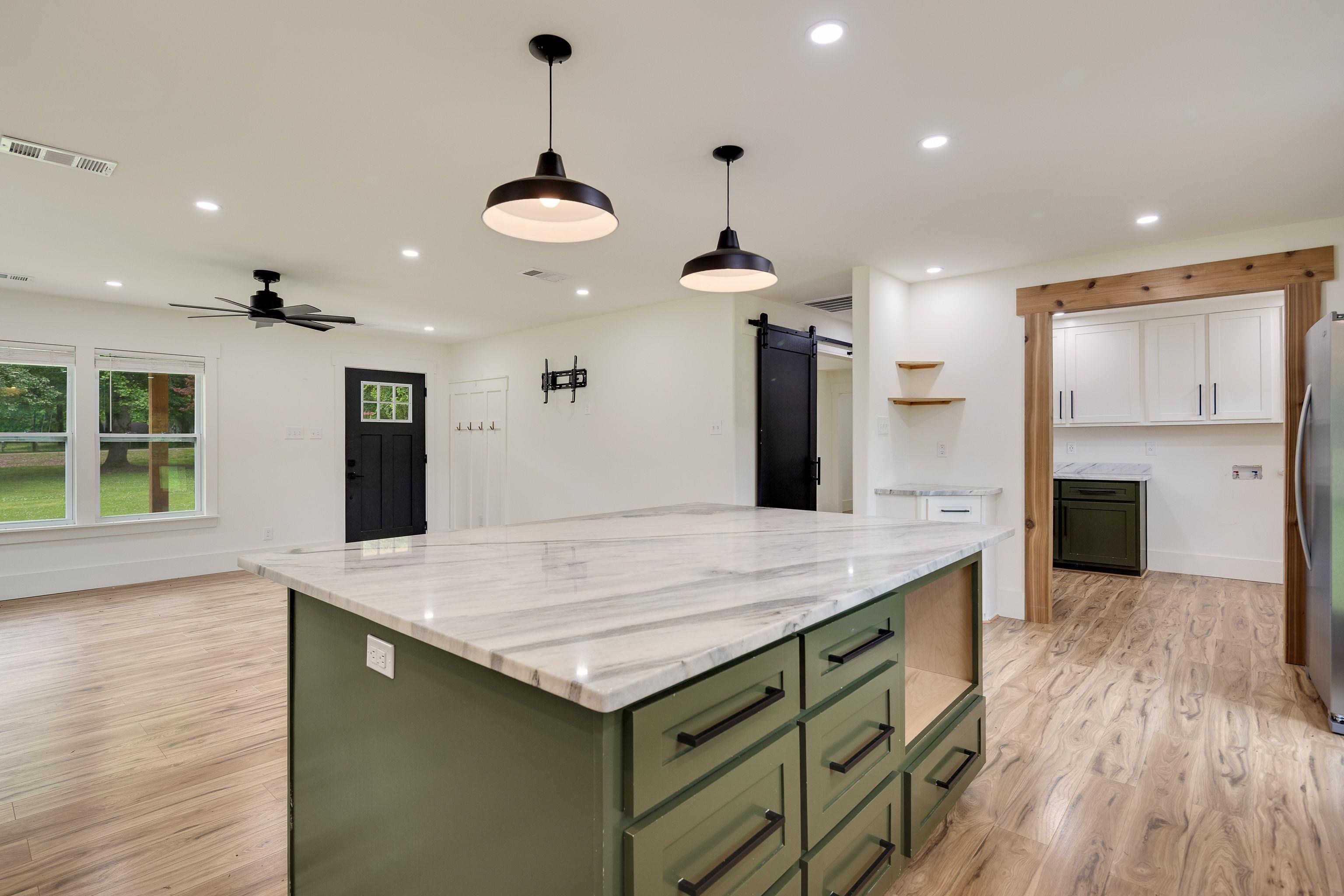 240 Dogwood Road Somerville, TN 38068 - Photo 12 of 37 a large kitchen with kitchen island a large island in the center a sink stainless steel appliances and cabinets