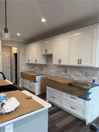 a kitchen with granite countertop a sink a stove and cabinets