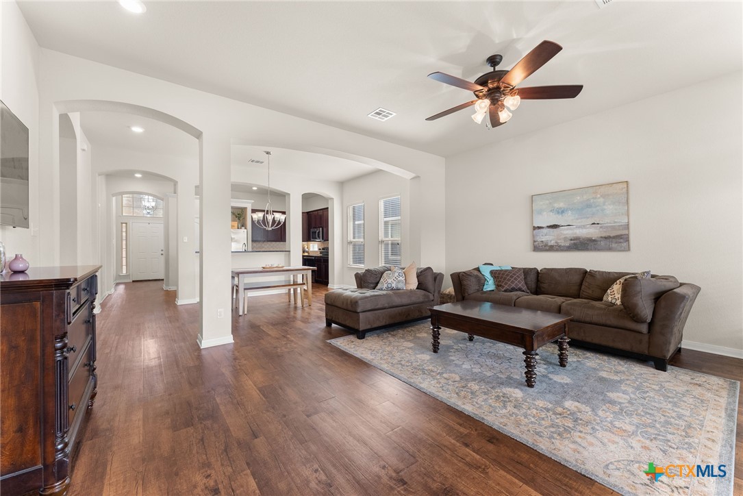 a living room with furniture and a wooden floor