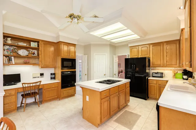a kitchen with stainless steel appliances kitchen island granite countertop a sink stove and refrigerator