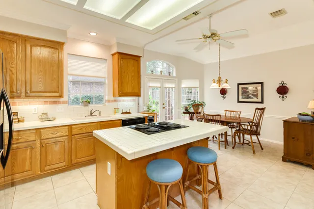 a kitchen with stainless steel appliances granite countertop table chairs sink and cabinets