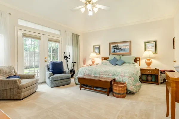 a spacious bedroom with a bed and glass window