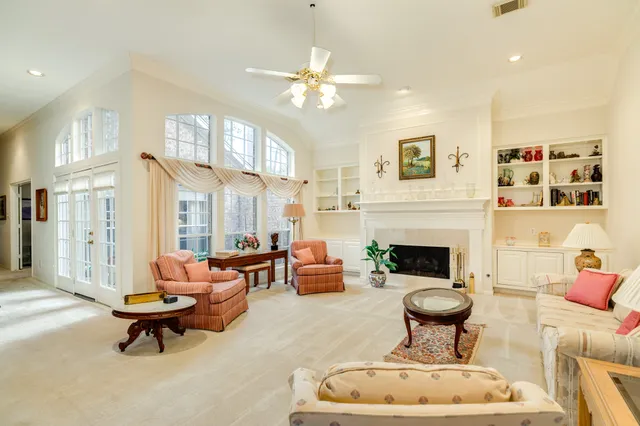a living room with furniture a fireplace and a chandelier