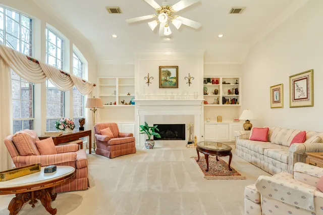 a living room with furniture a fireplace and a chandelier