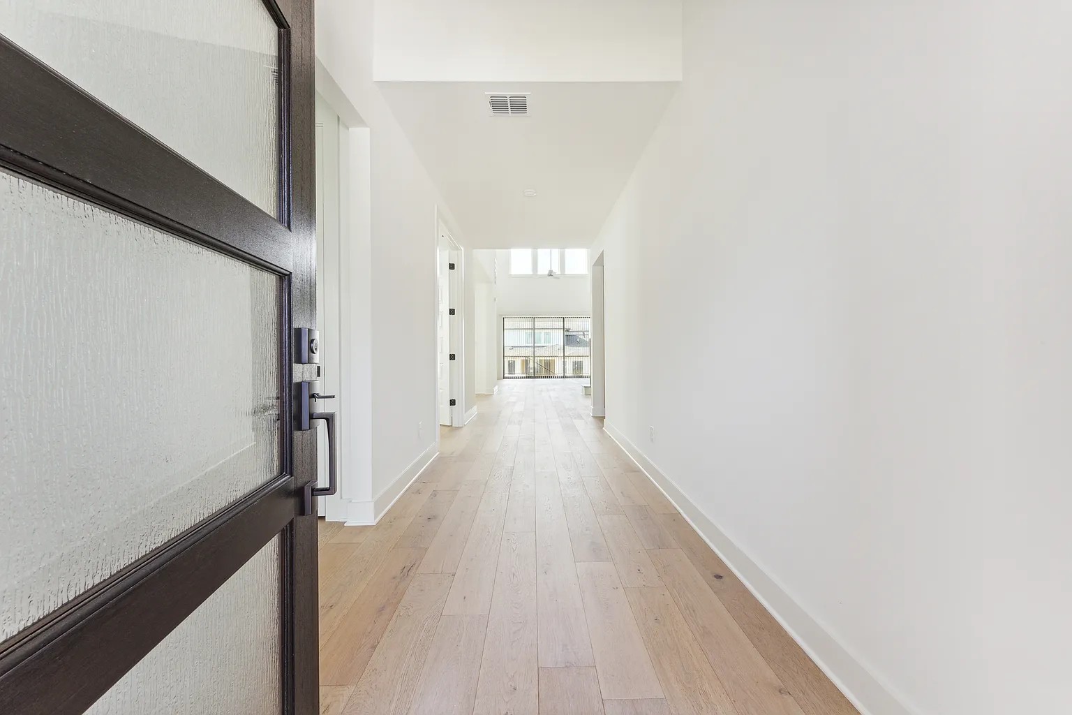 1909 Varese Path Leander, TX 78641 - Photo 3 of 40 Step into a luminous entryway featuring light wood flooring and crisp white walls.