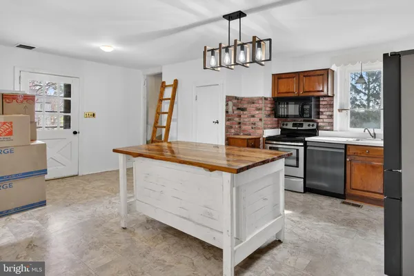 a kitchen with stainless steel appliances a sink stove and refrigerator