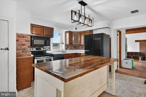 a kitchen with stainless steel appliances granite countertop a sink a refrigerator and a stove