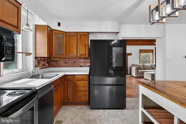 a kitchen with stainless steel appliances granite countertop a refrigerator a stove and a sink