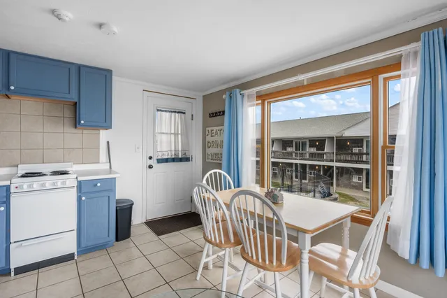 a dining room with furniture and large window