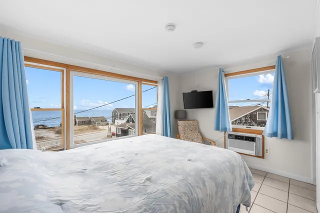 a bedroom with a large bed and a flat tv screen next to a window