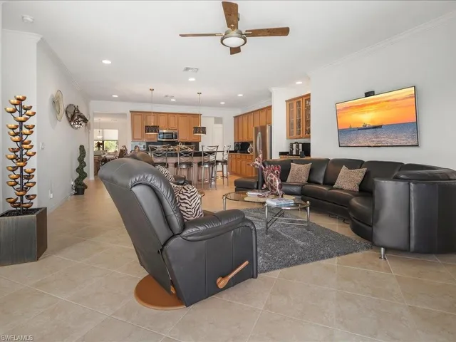 a living room with furniture a ceiling fan and a rug