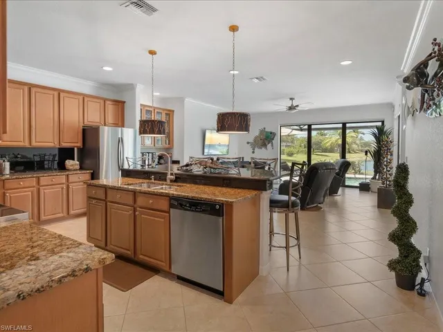 a kitchen with stainless steel appliances granite countertop a stove a sink a oven and a refrigerator with white cabinets