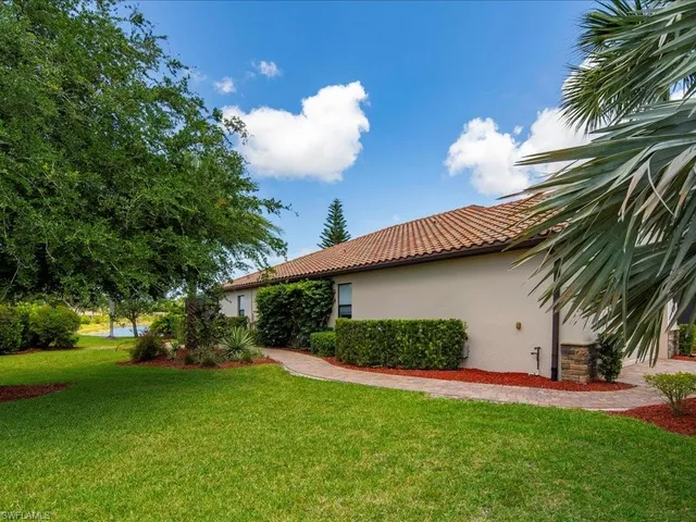 a view of a white house with a big yard and potted plants