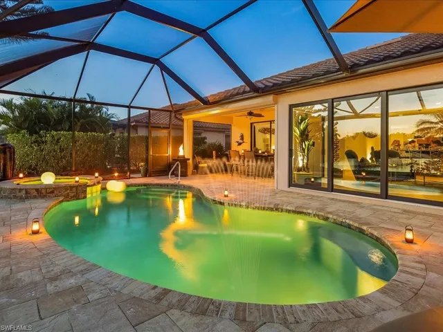 a view of a swimming pool with a table and chairs under an umbrella