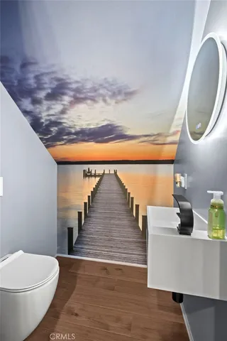 a kitchen with kitchen island granite countertop a sink cabinets and wooden floor