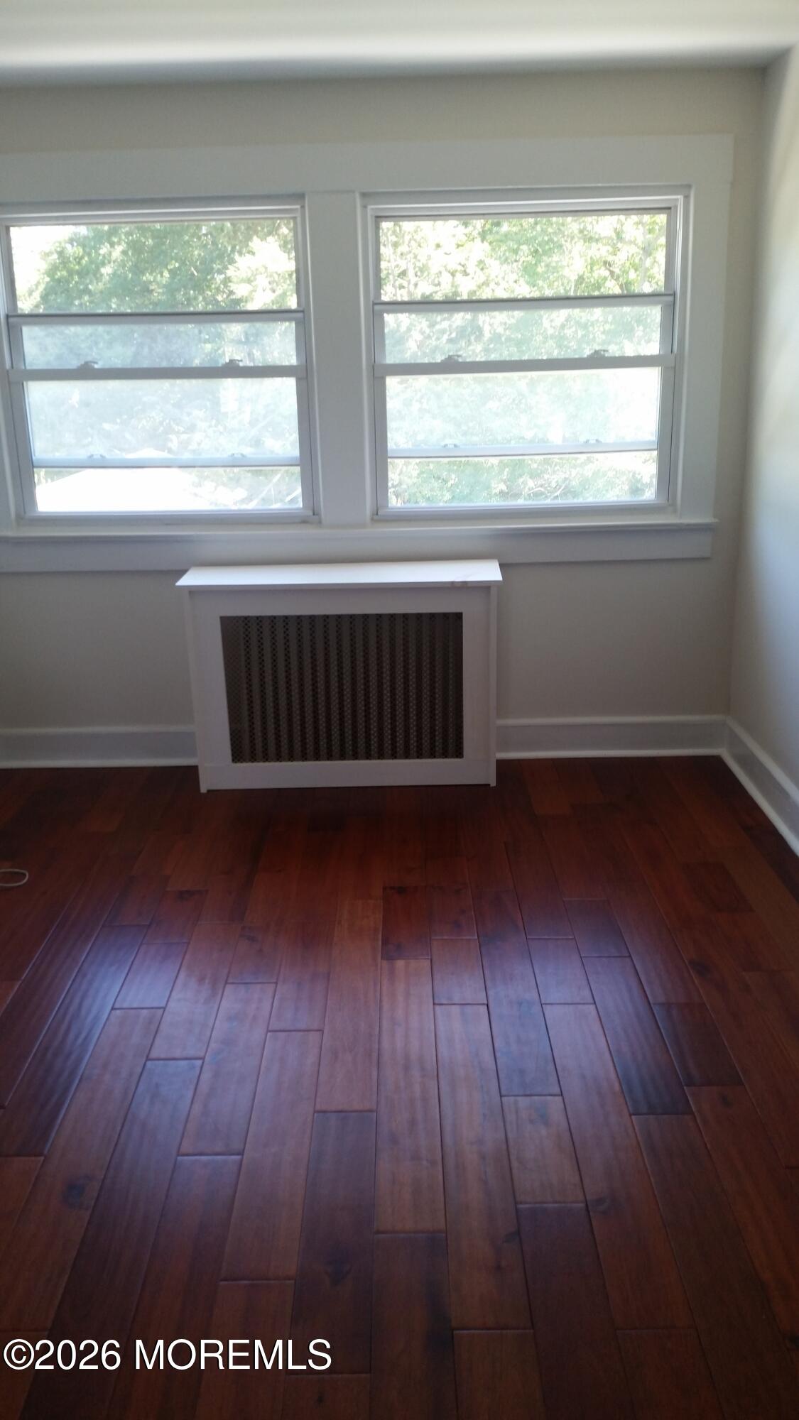 107 Broad Street, Unit B Matawan, NJ 07747 - Photo 9 of 10 an empty room with wooden floor and windows