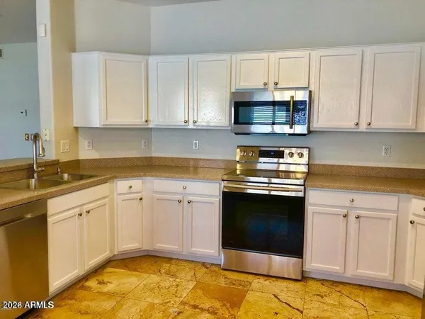 a kitchen with granite countertop a refrigerator sink and microwave