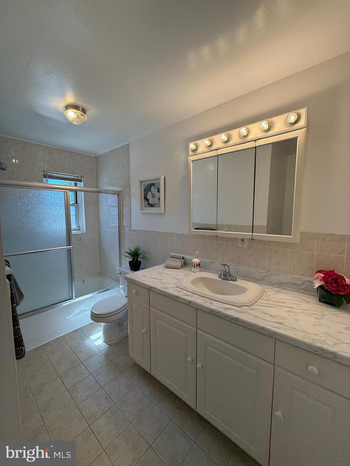 121 The Orchards, Unit I Cranbury, NJ 08512 - Photo 22 of 26 a bathroom with a double vanity sink mirror and toilet