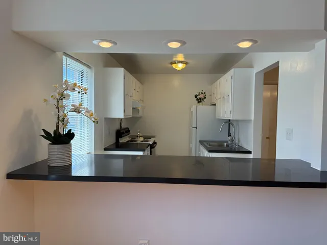 a kitchen with kitchen island a sink and a stove with wooden floor