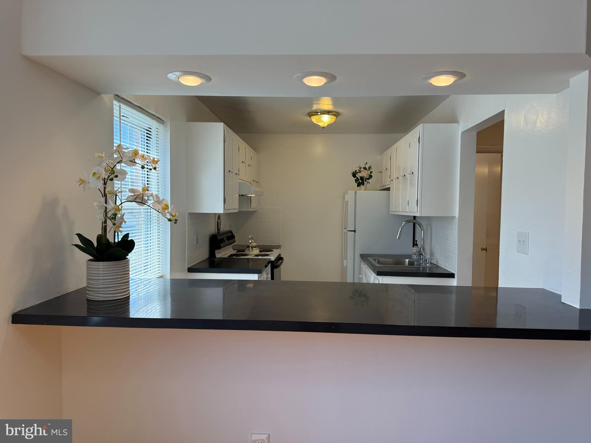121 The Orchards, Unit I Cranbury, NJ 08512 - Photo 10 of 26 a kitchen with kitchen island a sink and a stove with wooden floor