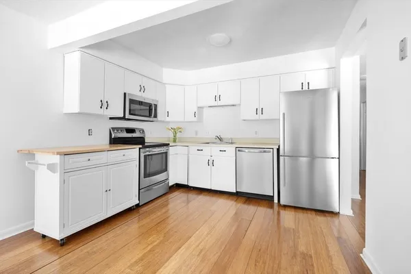 a kitchen with white cabinets and white appliances