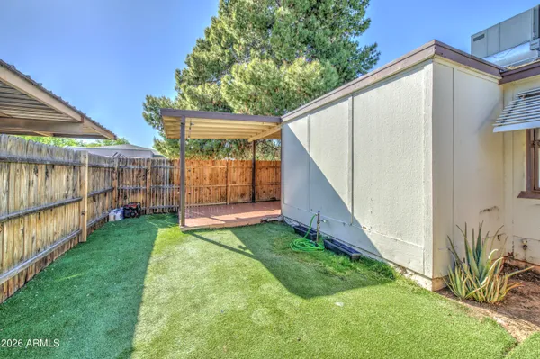 a view of backyard with small cabin and wooden fence