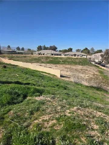 a view of a big house with a big yard and large trees
