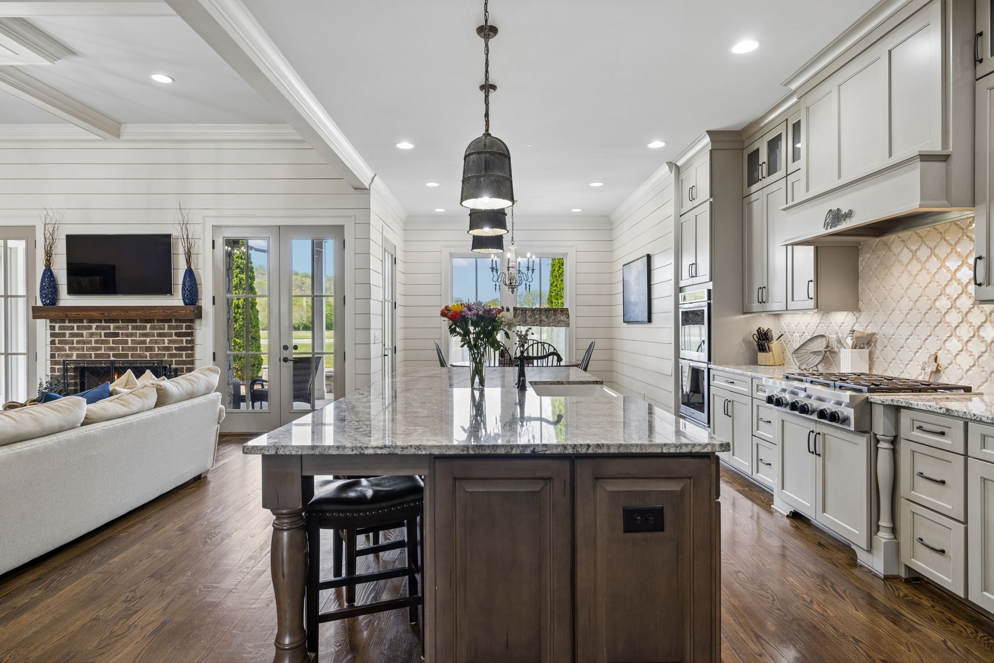 6033 Native Pony Trail College Grove, TN 37046 - Photo 33 of 87 a kitchen with stainless steel appliances granite countertop a stove top oven a sink dishwasher a dining table and chairs with wooden floor